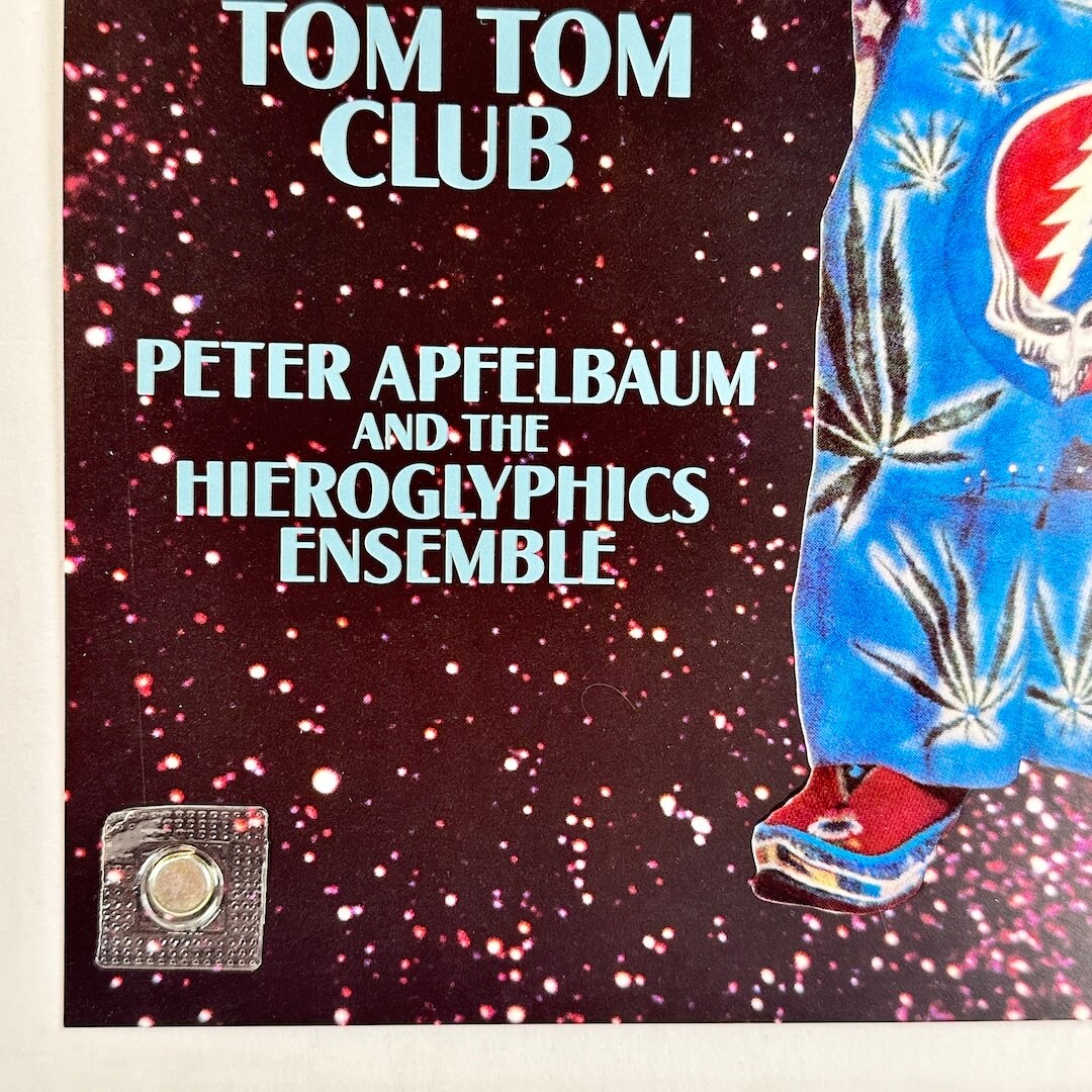 Bottom left corner of poster with no visible wear or damage held by magnet onto light surface. 