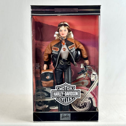 A Barbie doll dressed as a Harley-Davidson rider, standing inside its original retail packaging. 
