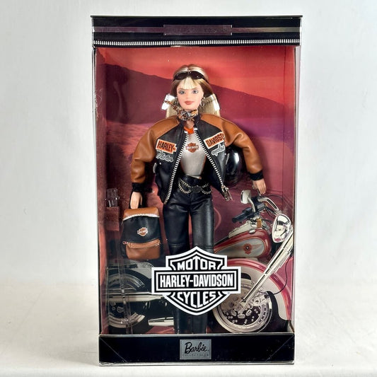 A Barbie doll dressed as a Harley-Davidson rider, standing inside its original retail packaging. 