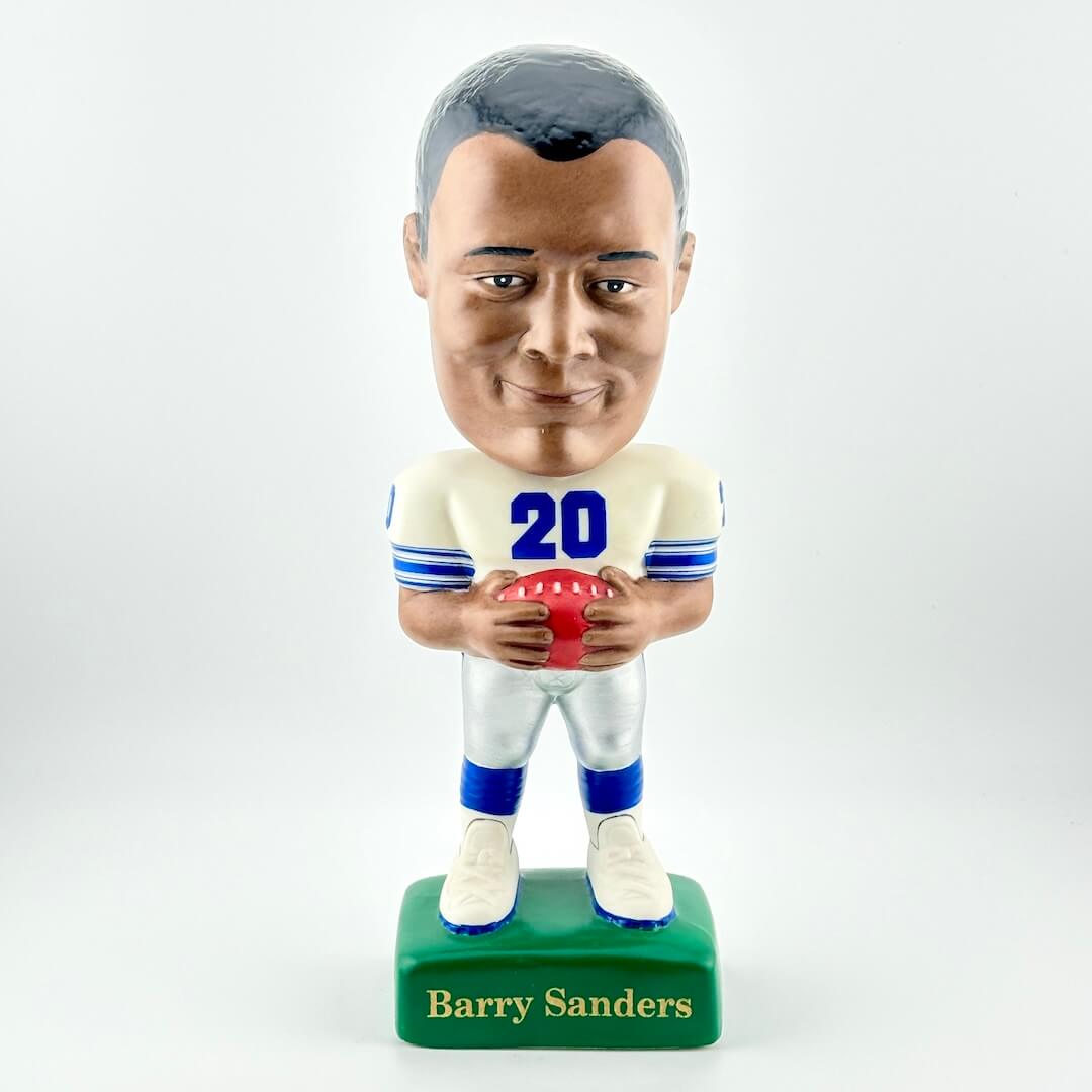 Bobblehead figure of a football player holding a ball on a white background