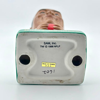 Under view of a toy figure with 'SAM, Inc.' branding and product details on a white background.