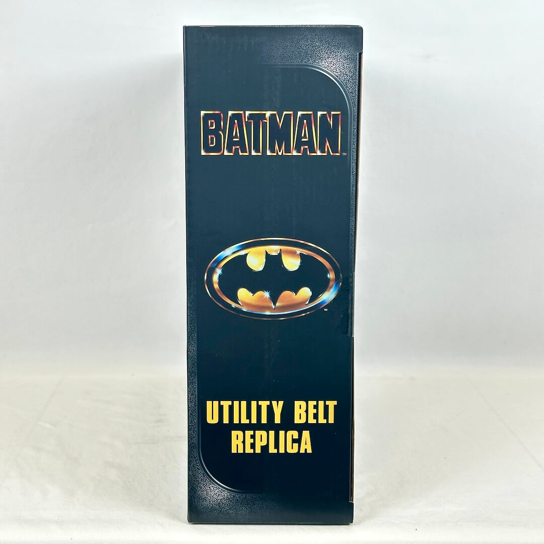 A tall, narrow product box for a Batman utility belt replica, featuring the Batman logo.