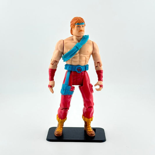 Action figure in red pants and blue accents against white background. 