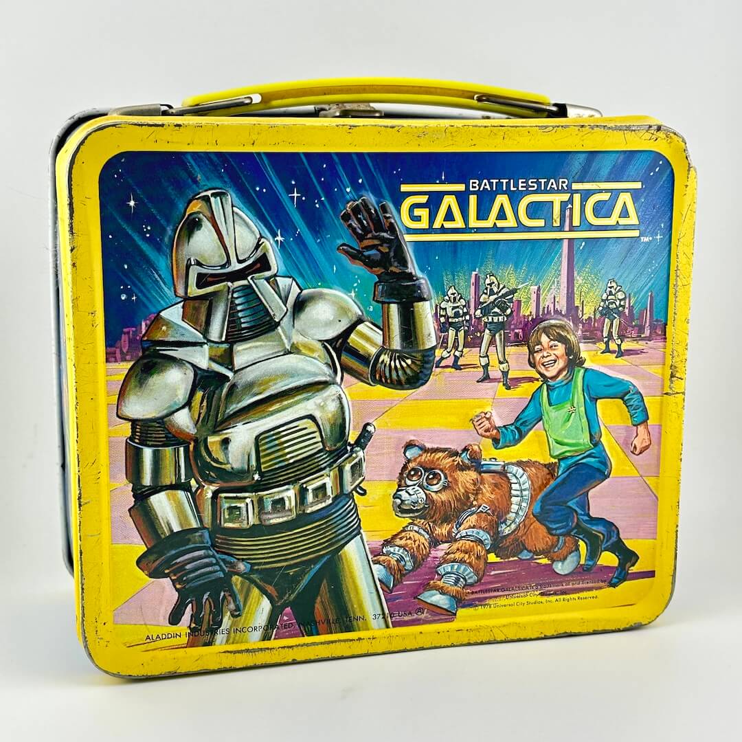 Vintage lunchbox with yellow border and sci-fi imagery with robots, aliens, and a child pictured. 
