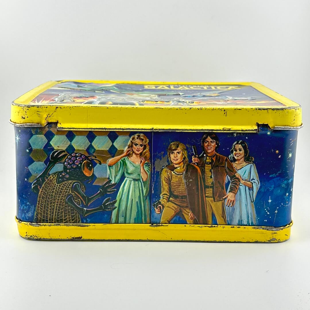Bottom of metal lunchbox with yellow border and colorful illustrations of characters from Battlestar Galactica. 