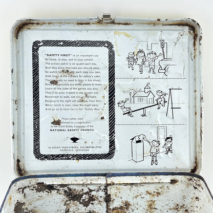 View of interior lid of vintage metal lunchbox showing safety instructions with illustrations. 