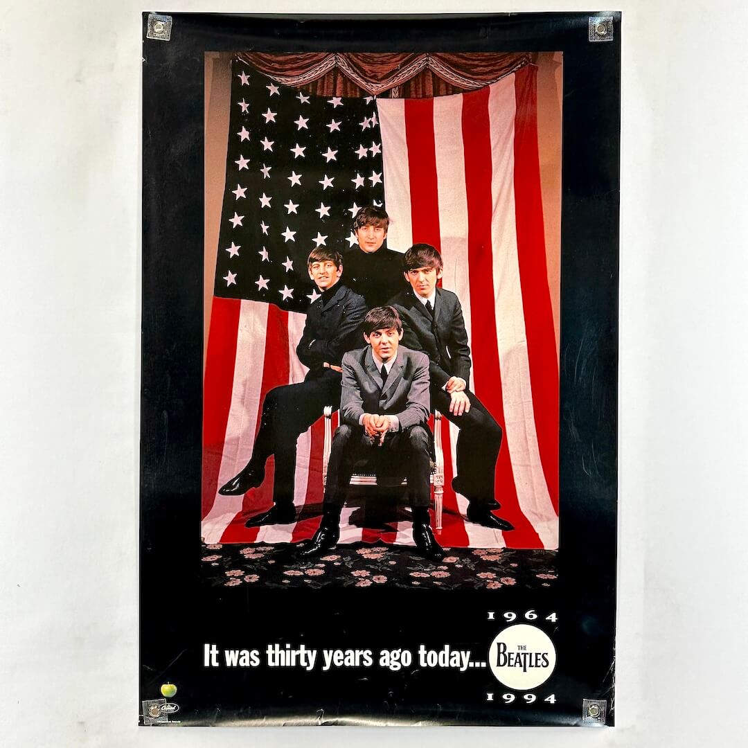 Poster of The Beatles in front of an American flag with text 'It was thirty years ago today... 1964 1994'.
