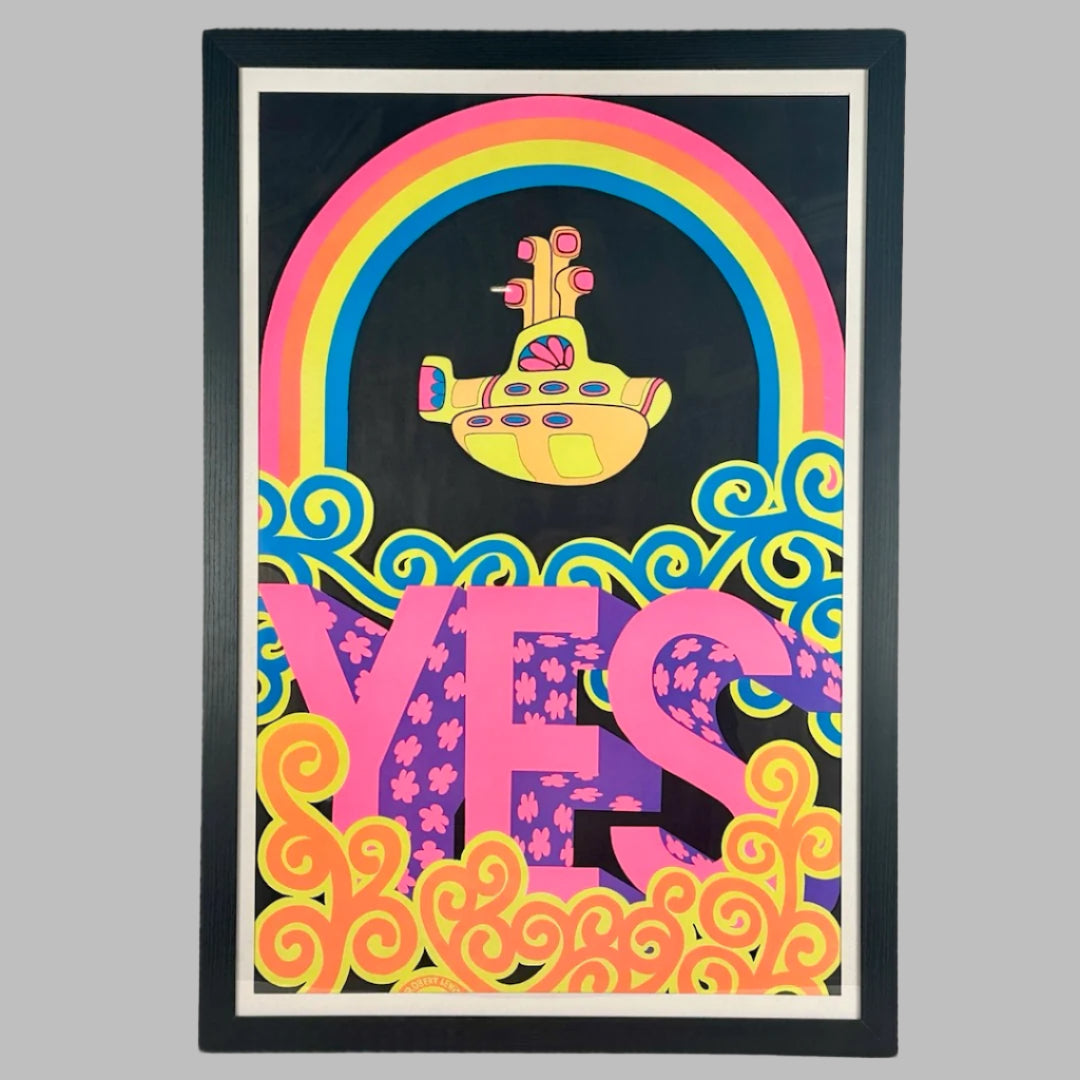 Framed black poster with bright color graphics: yellow submarine under rainbow, above pink/purple stylized YES set in swirls.