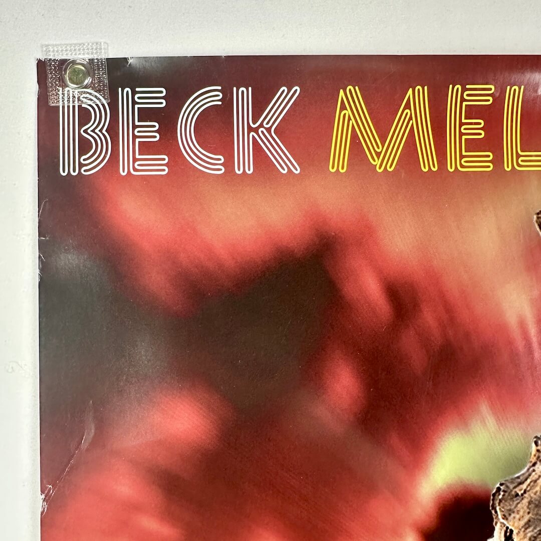 Top left corner of poster with crease and some edge wear visible. 