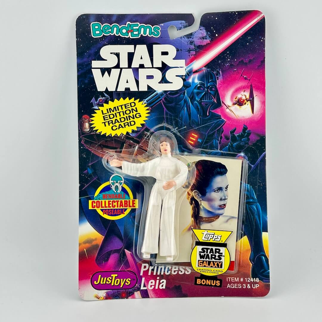 Princess Leia action figure in Star Wars branded packaging against gray background.
