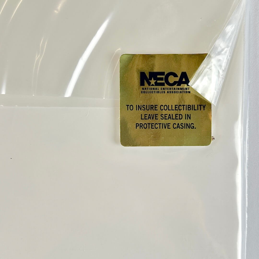 Gold label with 'NECA' text on a clear plastic casing