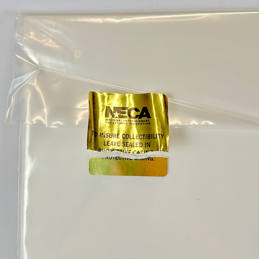 Gold NECA label on a clear plastic bag with a white background