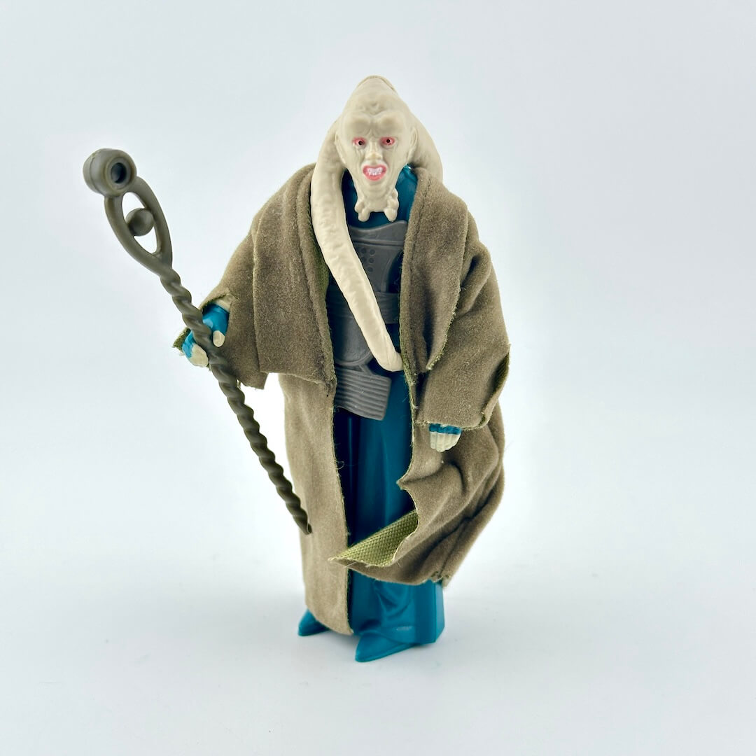 Toy figure of a character in a robe holding a staff on a white background