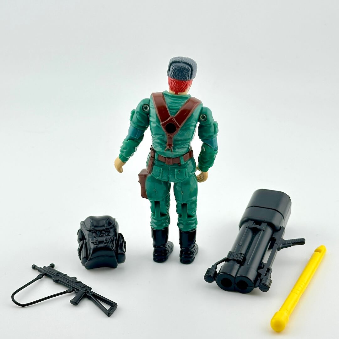 Toy figure in green outfit with accessories on a white background