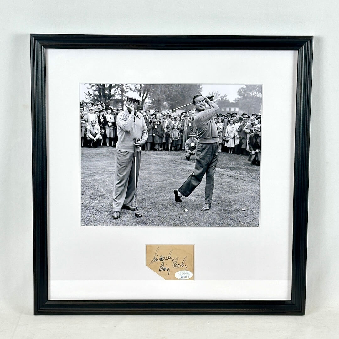 A framed black-and-white photograph of golfers on a course, mounted with a white mat and a black frame with signature at bottom. 
