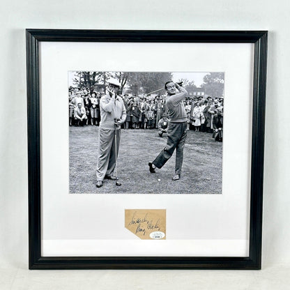 A framed black-and-white photograph of golfers on a course, mounted with a white mat and a black frame with signature at bottom. 
