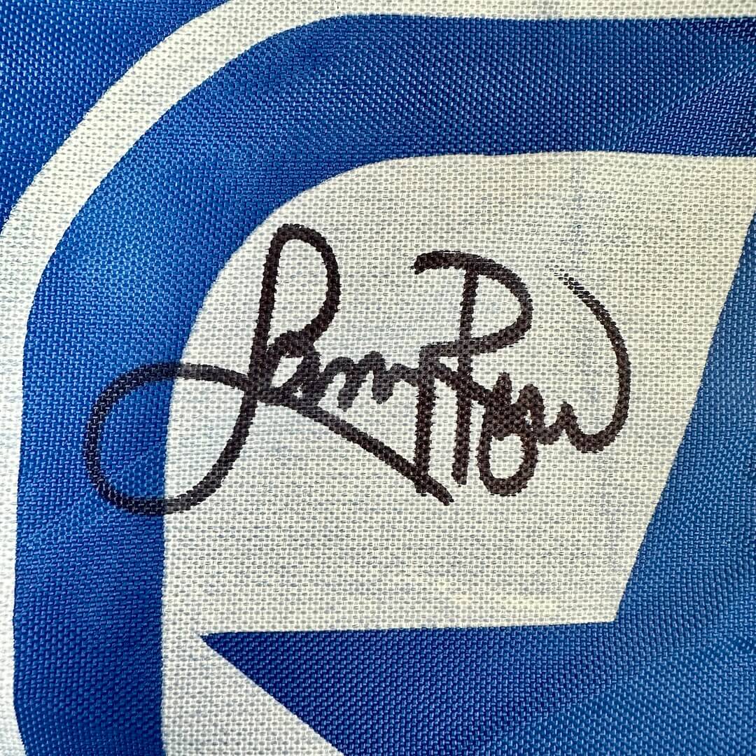 Signature on a blue and white sports banner. 