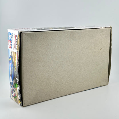 A plain brown cardboard box shown at an angle on a light gray studio background. Backside of packaging.