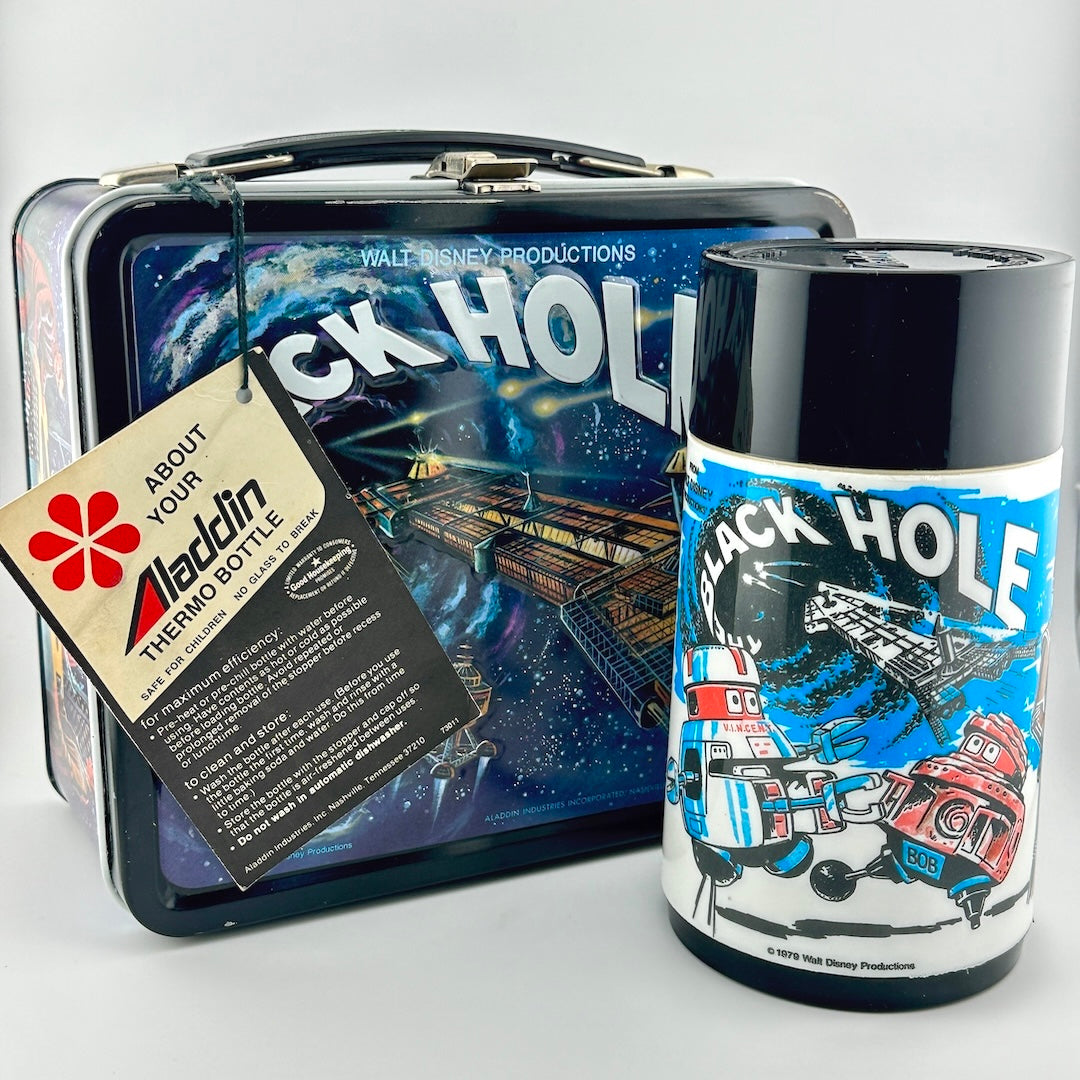 A vintage Aladdin 'Black Hole' thermos bottle displayed next to its original metal lunchbox case, images are sci-fi themed.