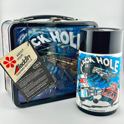 A vintage Aladdin 'Black Hole' thermos bottle displayed next to its original metal lunchbox case, images are sci-fi themed.