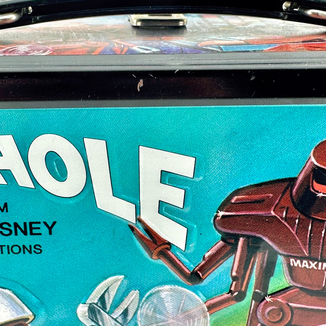 Close-up of a rectangular metal lunch box featuring a colorful robot sci-fi scene. 
