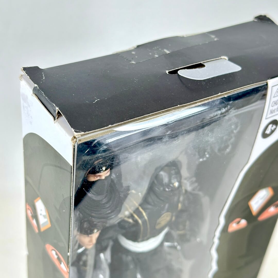 Close-up of wear to top of packaging and broken factory seal. 