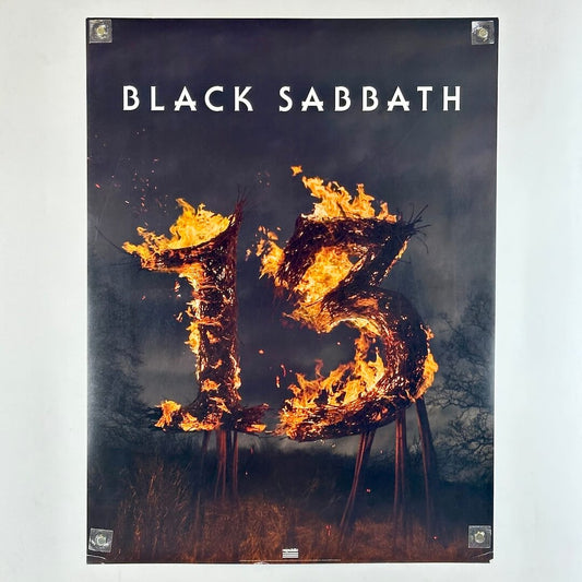 Black Sabbath poster with flaming "13". in center with brush around it. 