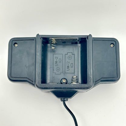 Black remote control with battery compartment visible with no corrosion. 