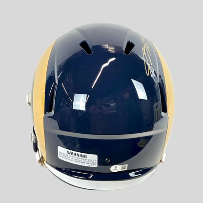 Back view of navy blue football helmet with warning and authentication stickers. 