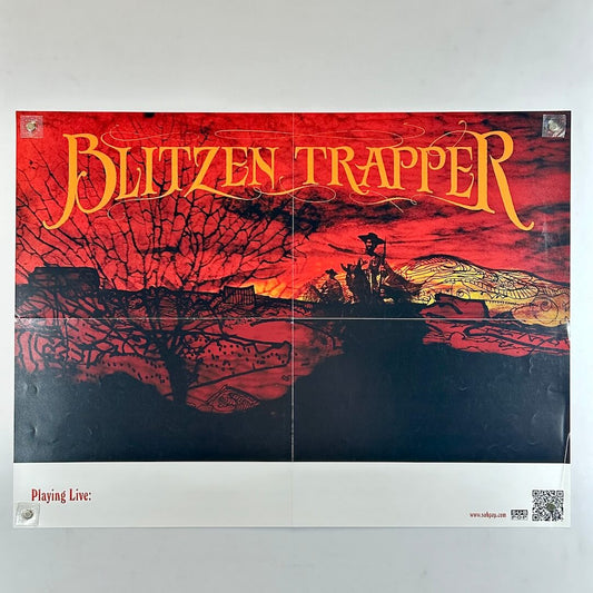 Red landscape with yellow text 'Blitzen Trapper' with white banner along bottom. 