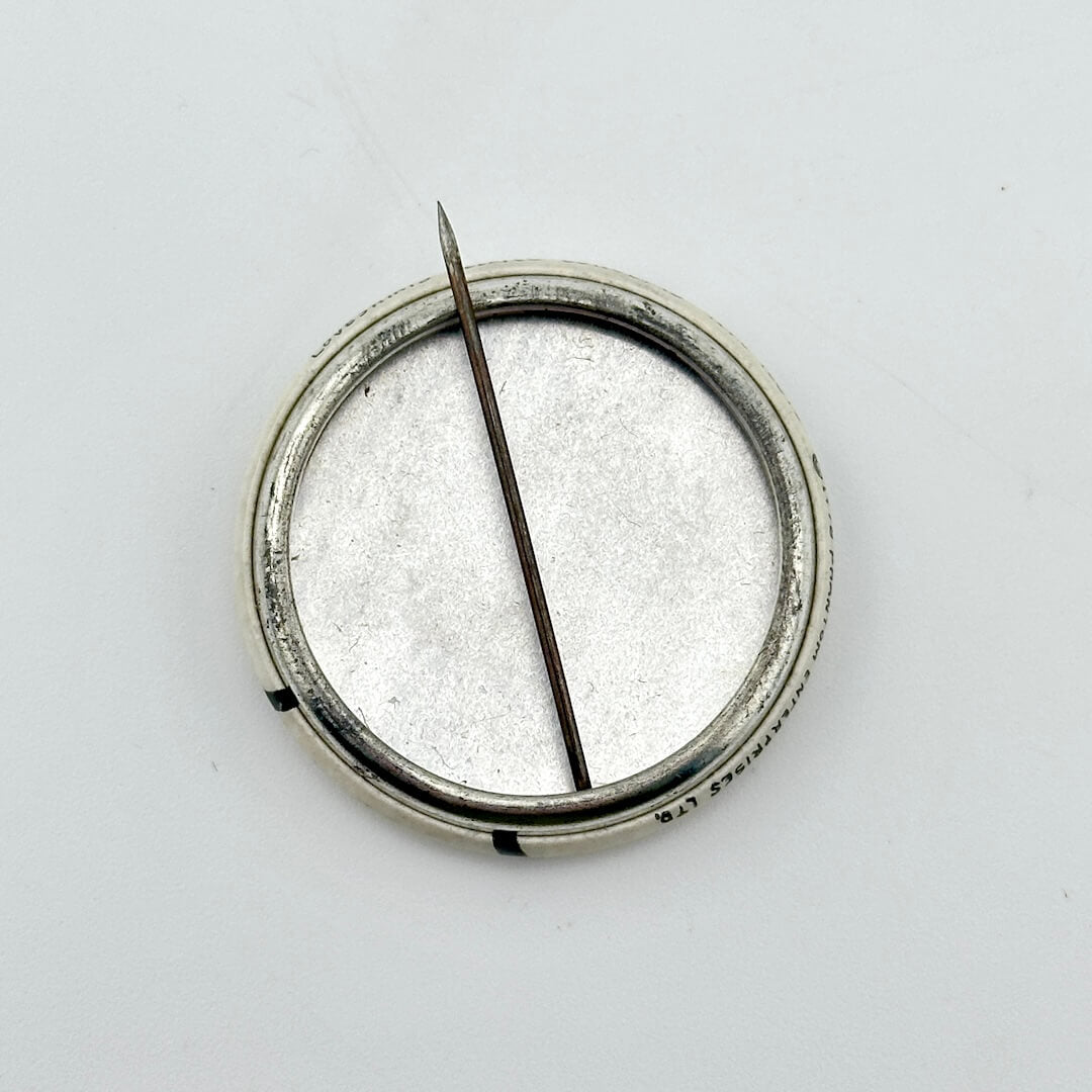 Round metal object with a central rod on a white background