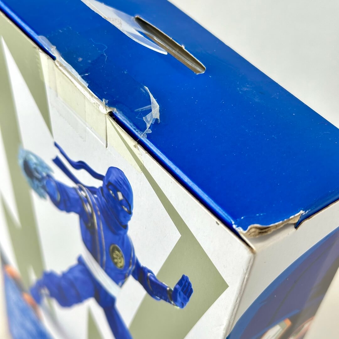 Close-up of broken factory seal and some wear to lid of box. 