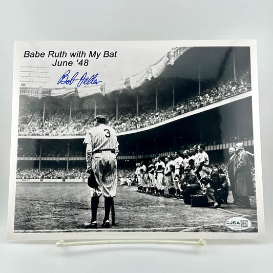 Black and white photo of Babe Ruth with a bat, signed by Bob Feller, at a baseball game.