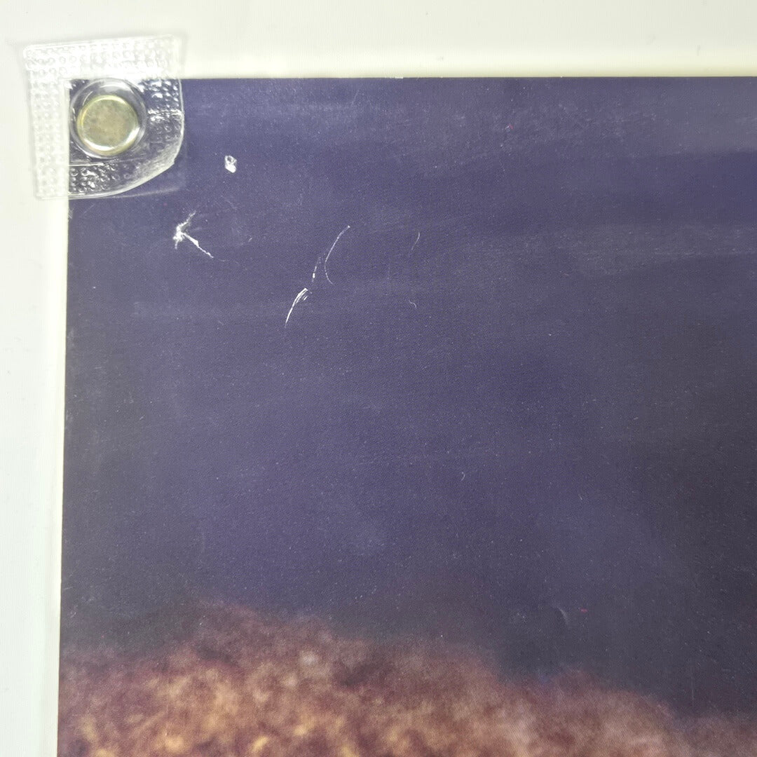 Top left corner of poster with pin holes and scratch