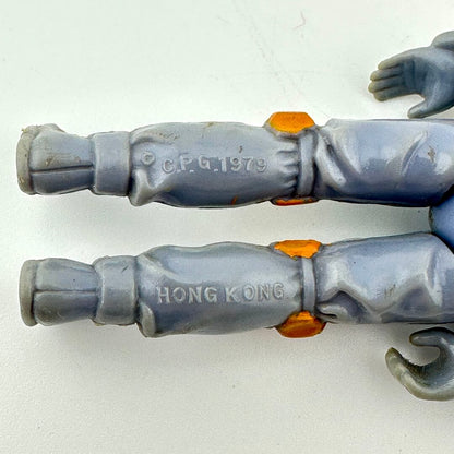 Close-up of a toy figure with 'C.F.G. 1979' and 'HONG KONG' text on gray arms.