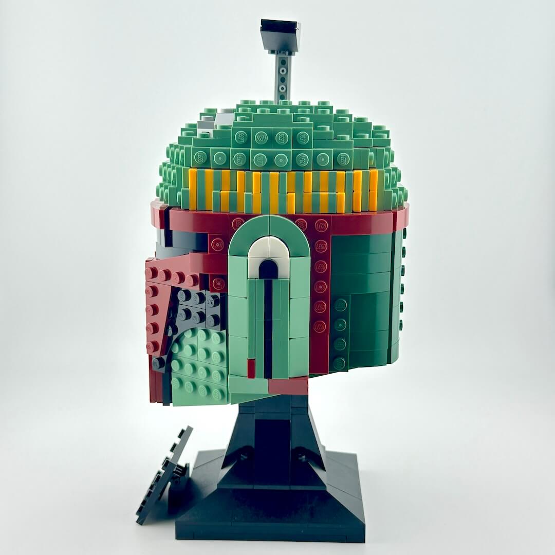 Assembled Lego bust of Boba Fett against white background, side view.