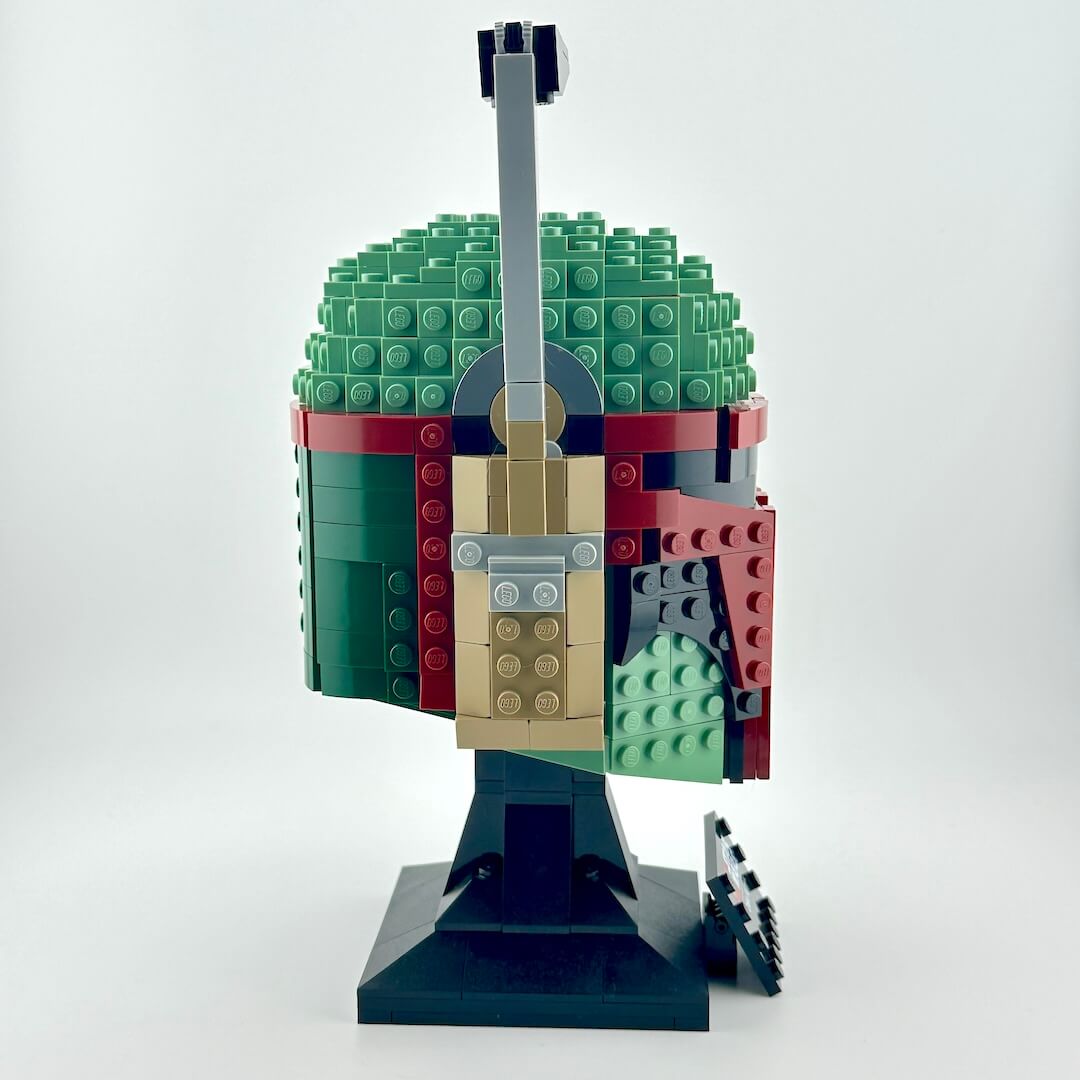 Assembled Lego bust of Boba Fett against white background, side view.
