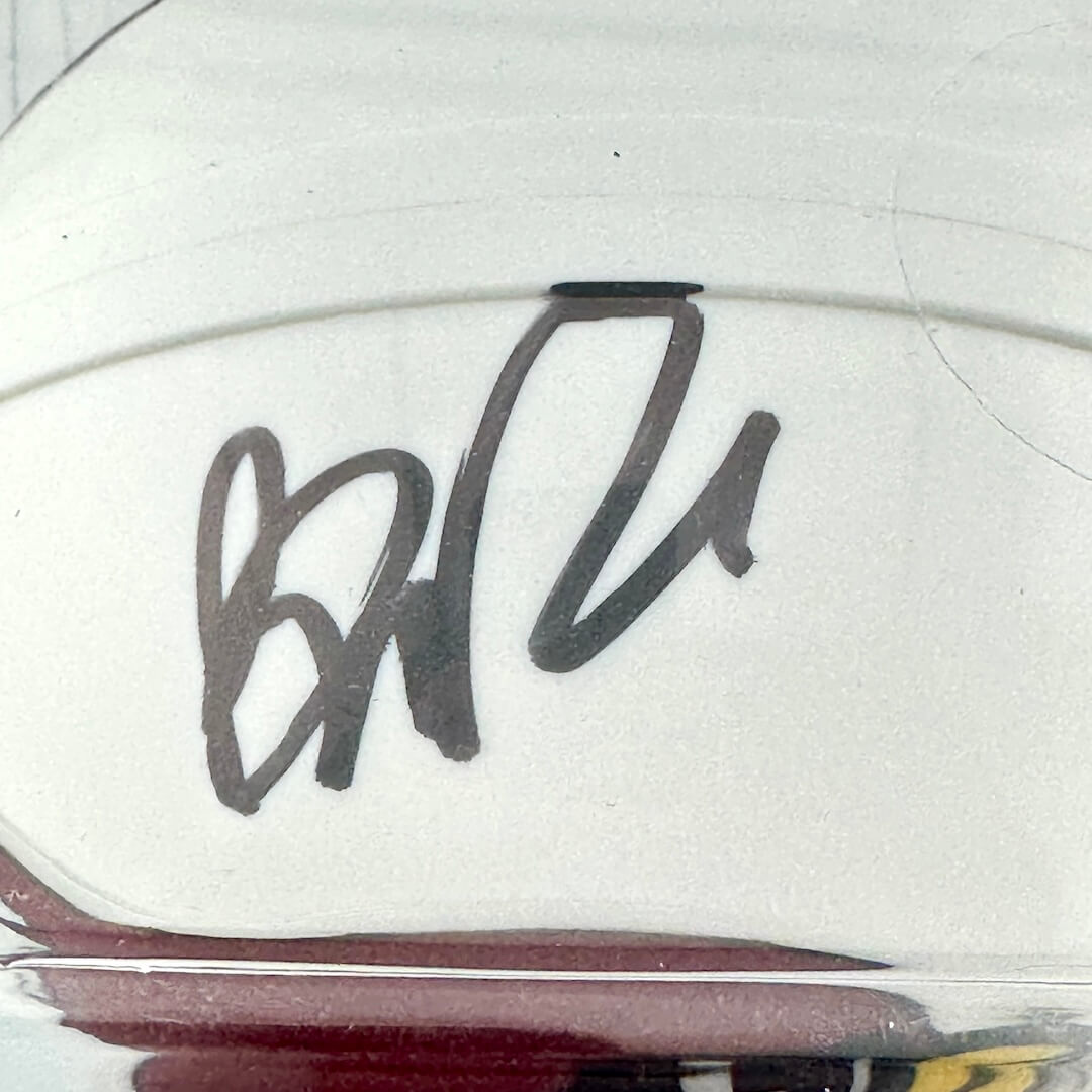 Close-up of a signature on a white surface with a blurred background