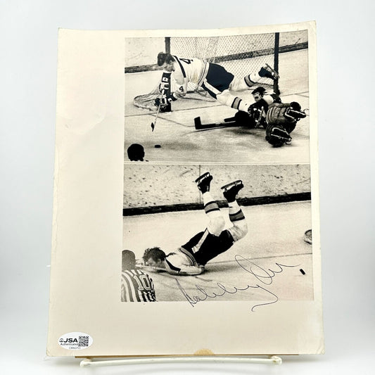 Hockey game action photo with a player diving for the puck with a JSA sticker.
