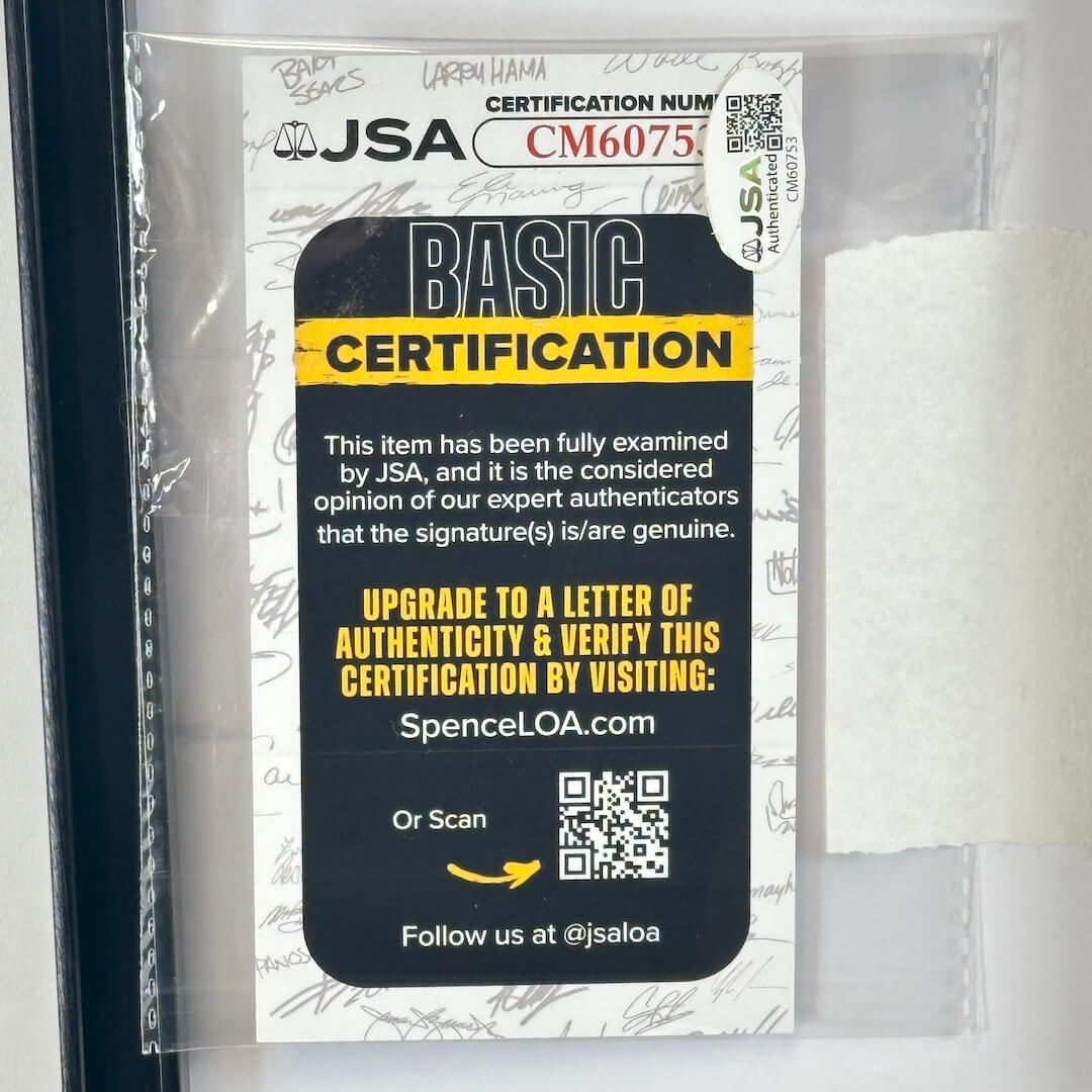A JSA Basic Certification card in a clear protective sleeve, showing a black and yellow certificate panel with text and QR codes. 