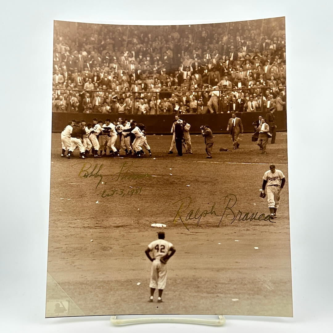 Vintage black and white photograph of a baseball game with players on the field and a crowd in the stands.