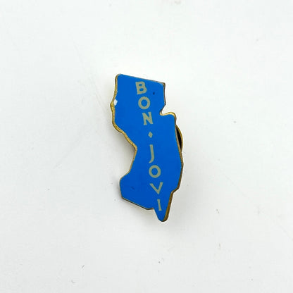Blue enamel pin with 'BON JOVI' text on a white background
