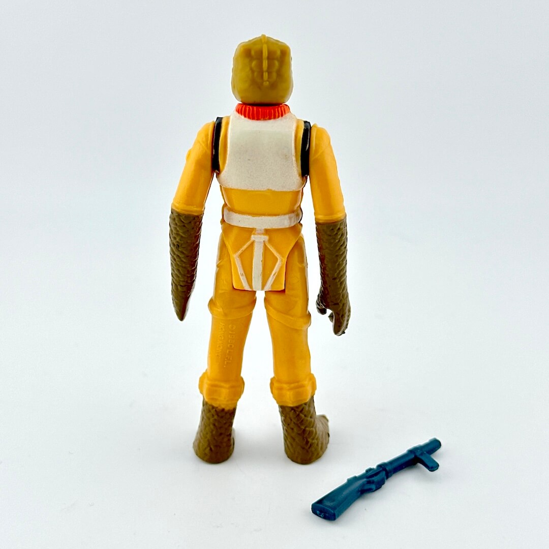 Toy figure in yellow outfit with blue weapon on a white background