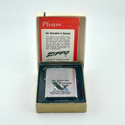 A vintage Zippo novelty lighter displayed in an open gold-colored presentation box, with the branded inner card. 