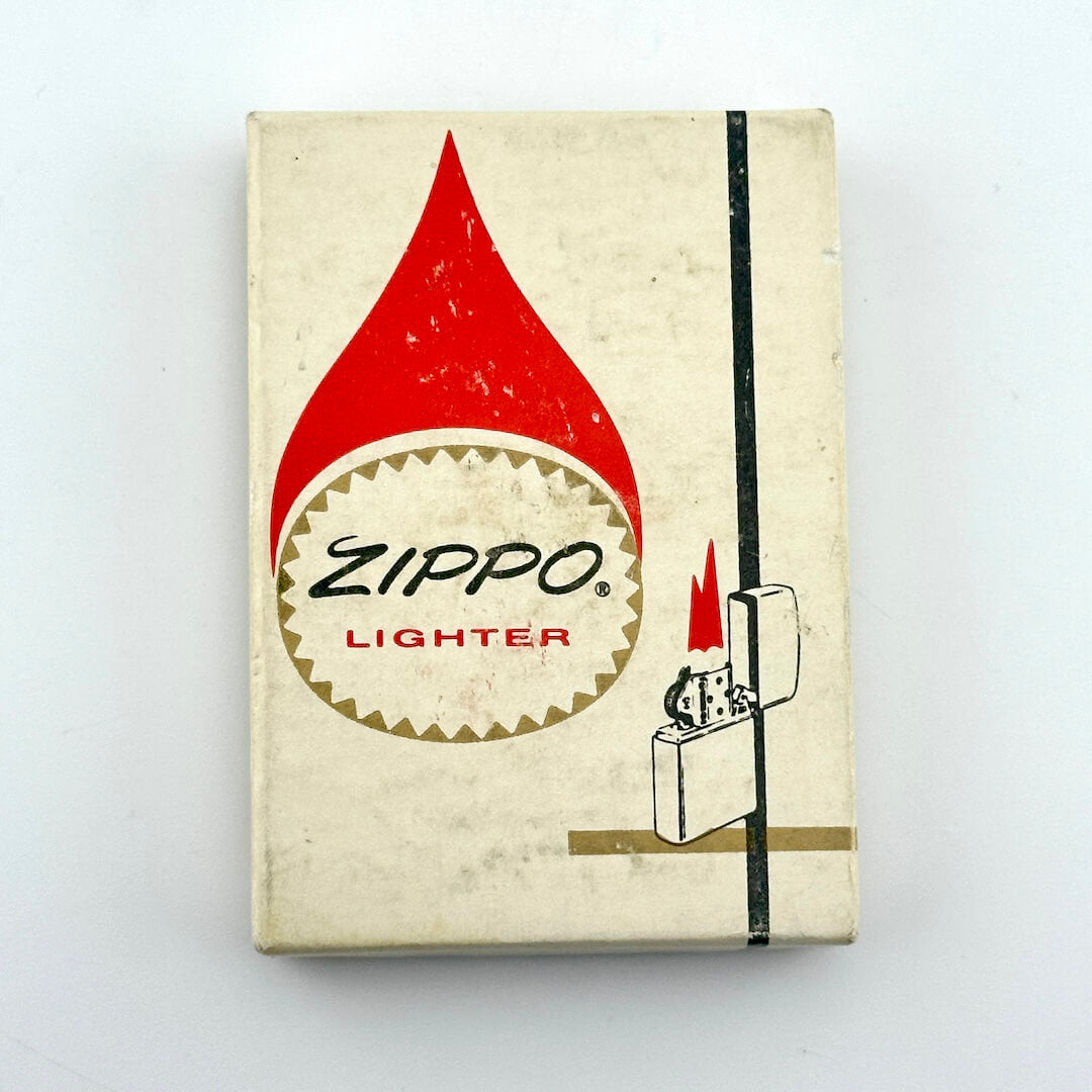 Vintage Zippo Lighter matchbox cover, showing the classic red flame logo and Zippo brand name on an off-white background.