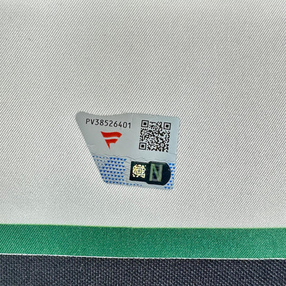A close-up of a white textured fabric surface with a small printed label showing a red logo, and a QR code.