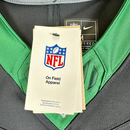 Close-up of a Nike NFL jersey with a visible NFL On Field Apparel hangtag and a Nike tag inside the collar. 