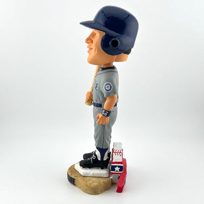 Bobblehead of a baseball player in a gray uniform with a helmet on a white background