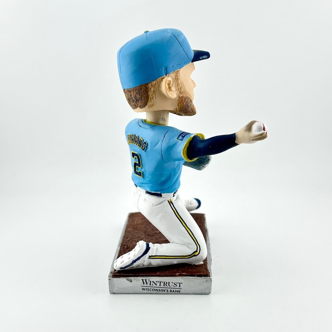 Bobblehead of baseball player in blue uniform throwing a ball against a white background. 