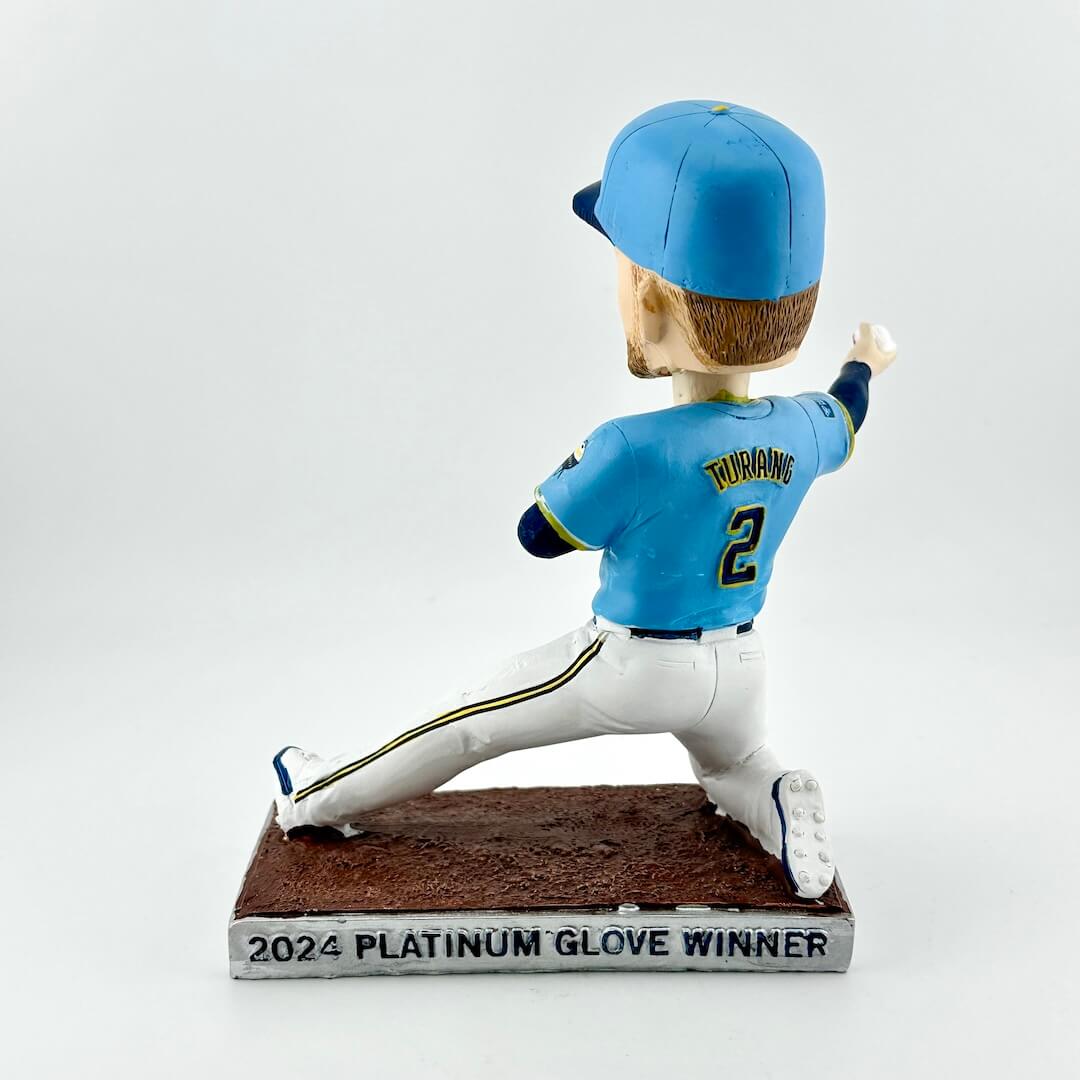 Bobblehead of baseball player in blue uniform throwing a ball against a white background. 